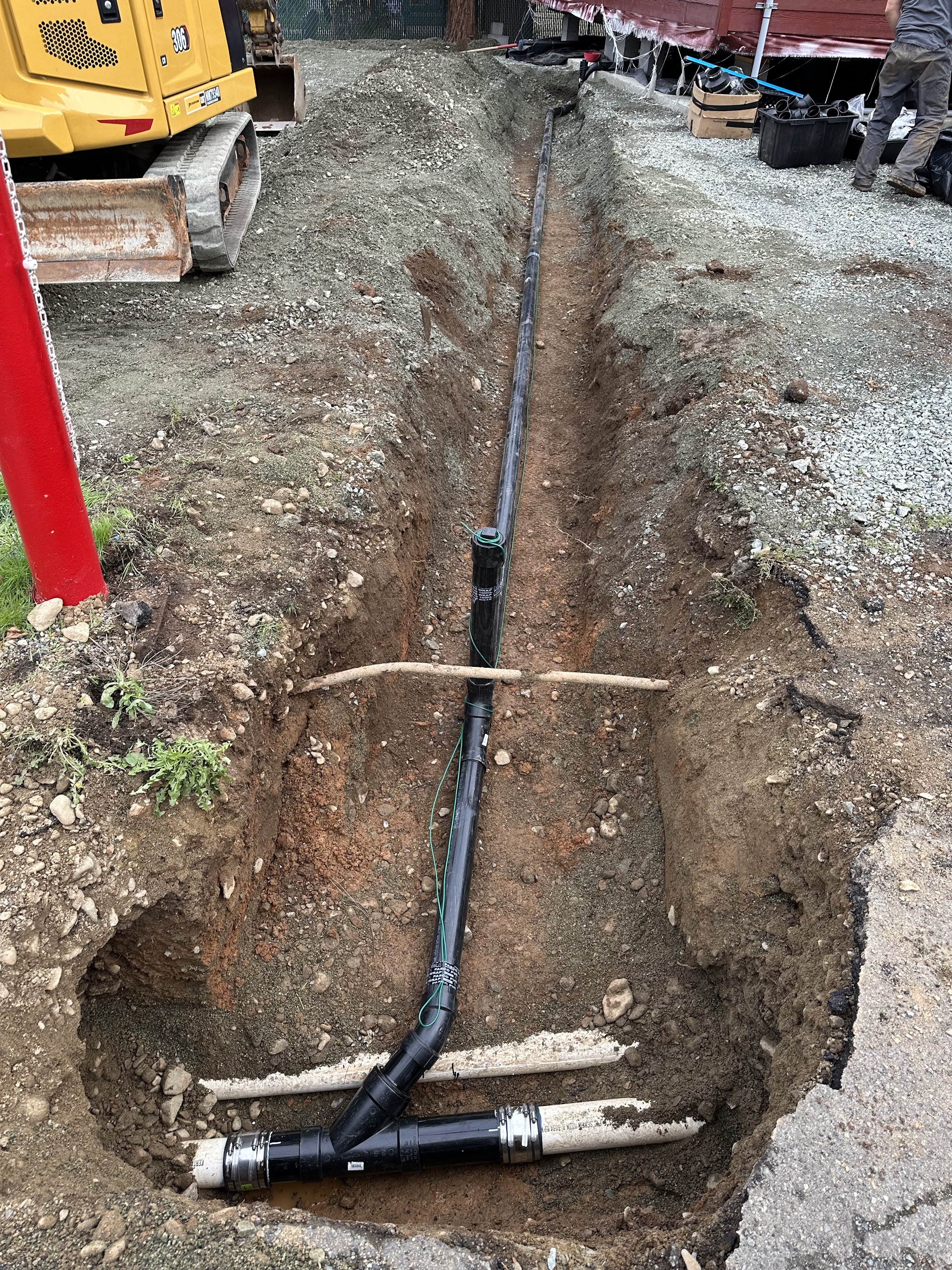 Sewer line trench with fittings staged before backfill