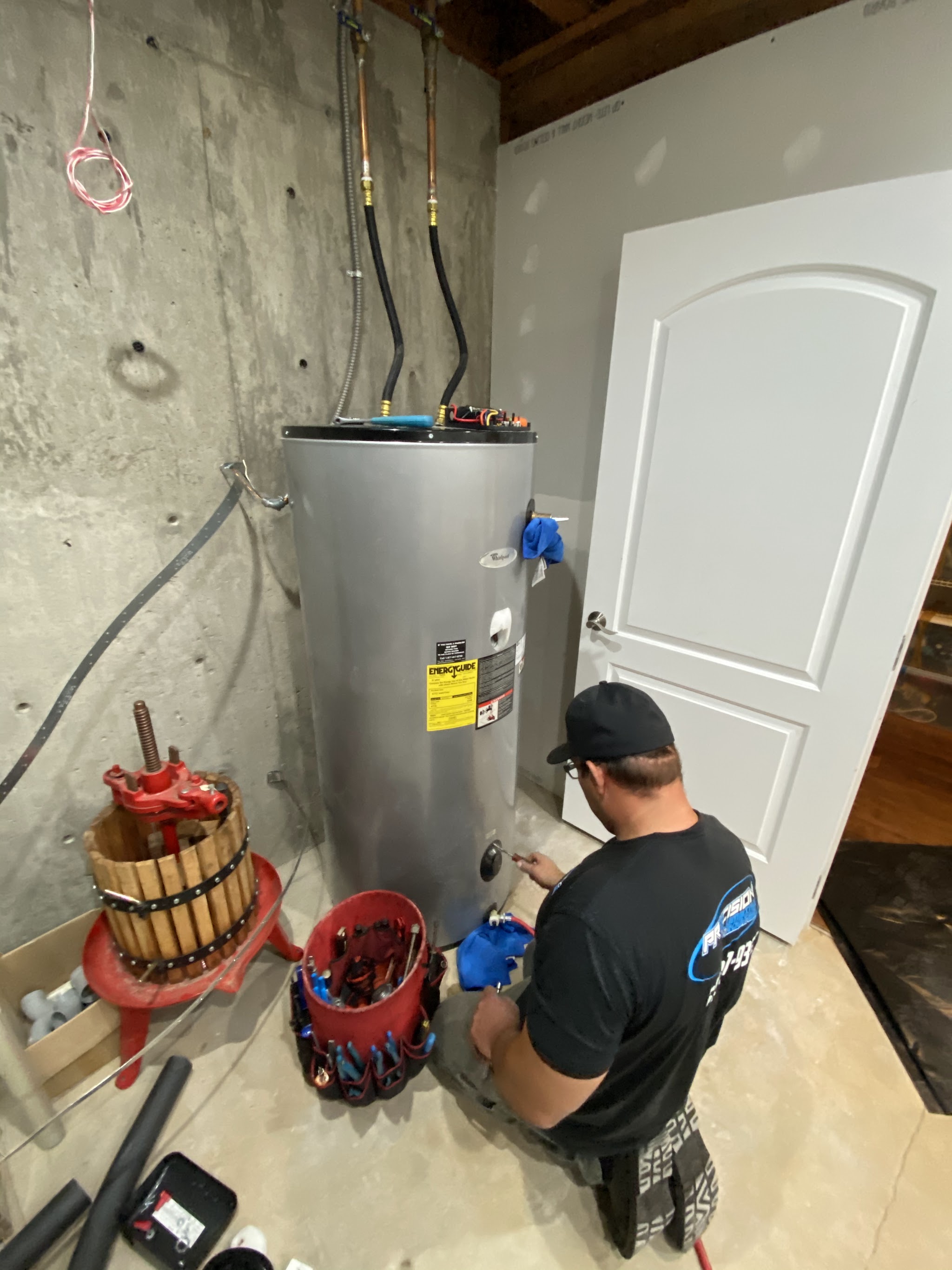 Precision Plumbing technician installing a residential water heater