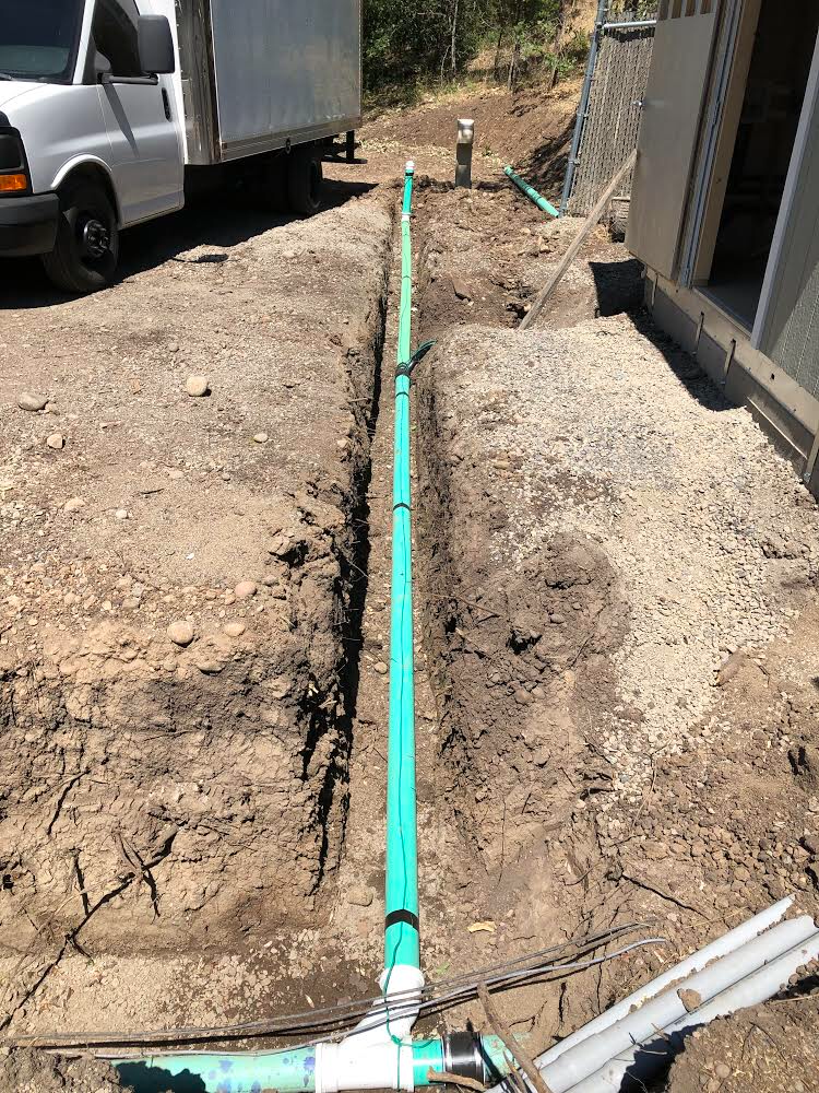Precision Plumbing technician working an outdoor water line repair